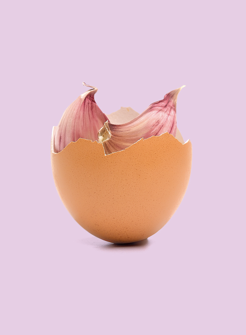 Imagen publicitaria de media cáscara de huevo con dientes de ajo en su interior