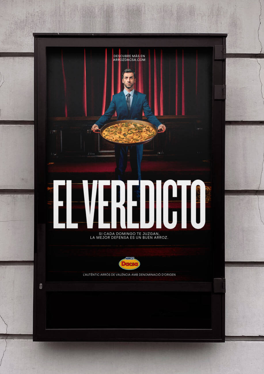 Cartel vertical publicitario de un actor sosteniendo la paella con el texto El veredicto, si cada domingo te juzgan la mejor defensa es un buen arroz